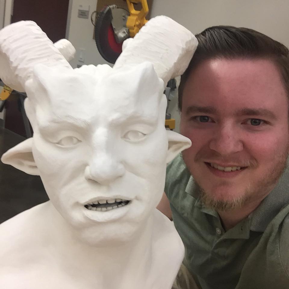 image of tait loughridge posing with a ceramic bust of his creation